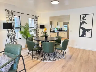 a dining room with a table and green chairs at Modern Duplex with 6 beds and Sofa bed in Miracle Mile Longwood in Los Angeles