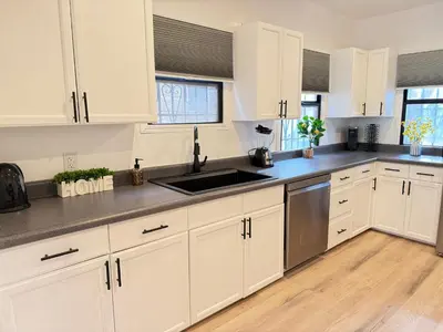 a kitchen with white cabinets and a sink at Modern Duplex with 6 beds and Sofa bed in Miracle Mile Longwood in Los Angeles