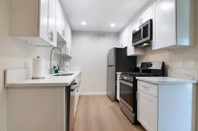a kitchen with white cabinets and a stove top oven at Stylish 1BR Near Universal Studios with Parking in Los Angeles