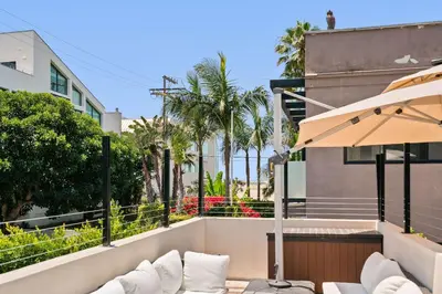 a balcony with white chairs and an umbrella at New Listing Marina Villa by Colby & Conrad in Los Angeles