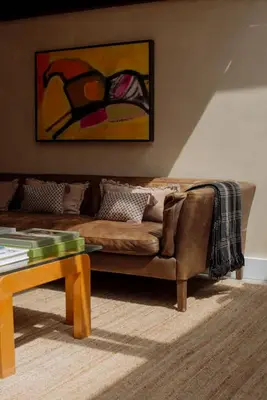 a living room with a brown couch and a table at Mane & Saddle Loft in Los Angeles