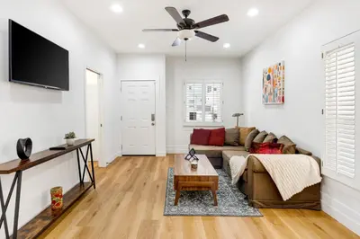 a living room with a couch and a flat screen tv at Adorable Pasadena Bungalow in Pasadena