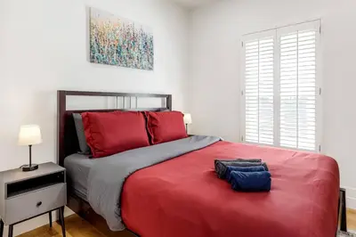 a bedroom with a large bed with red pillows at Adorable Pasadena Bungalow in Pasadena