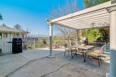 a pergola with a table and chairs on a patio at Quiet Home with Spectacular Scenic Mountain Views near Universal Studios Hollywood in Los Angeles