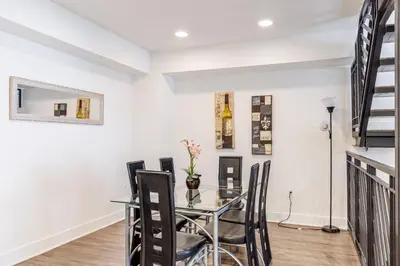 a dining room with a glass table and chairs at Sunset Boulevard Apartments in Los Angeles