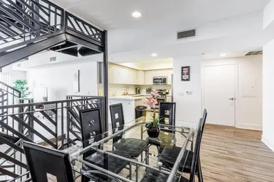 a dining room and kitchen with a glass table and chairs at Sunset Boulevard Apartments in Los Angeles