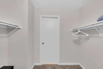 a bathroom with white walls and a glass door at Sunset Boulevard Apartments in Los Angeles