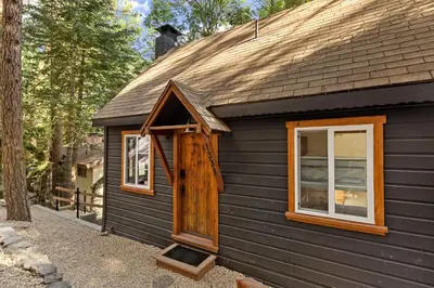 a black house with a window on the side of it at Cute Romantic Cabin With Hot Tub 5 Min from Lake in Crestline