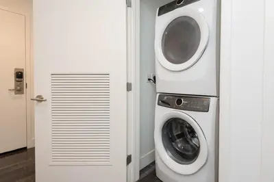 a washing machine and a washer and dryer in a room at Stunning 3BR High Rise Pool, Spa & Rooftop Views in Los Angeles