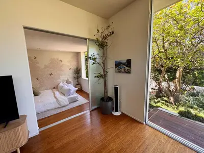a living room with a large glass window and a couch at Venice Walk Street Retreat Jacuzzi and Lemon Tree in Los Angeles