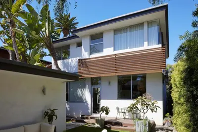 a house with wooden shutters on the facade at Architectural Walk Street Home Venice Elegance in Los Angeles
