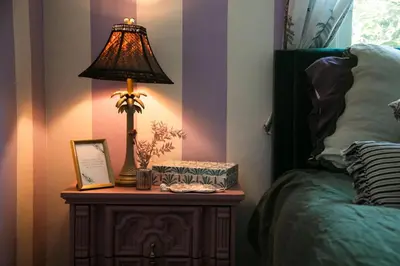 a lamp on a table next to a bed at Casa Cleopatra Bold Design, Pool and Privacy in Los Angeles