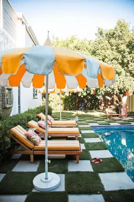 an orange and white umbrella sitting next to a pool at Casa Cleopatra Bold Design, Pool and Privacy in Los Angeles
