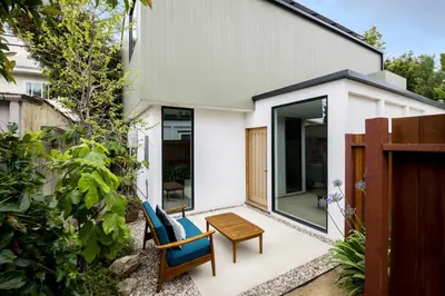 a patio with two chairs and a table in front of a house at Modern Mar Vista Hideaway New TwoStory ADU in Los Angeles
