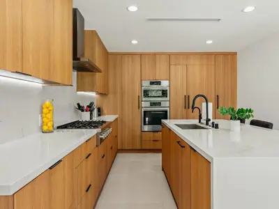a kitchen with wooden cabinets and white counter tops at Casa Leona in Los Angeles
