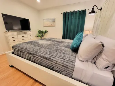 a bedroom with a large bed with a television and a bedskirtspectspectspects at Private and large 2 bedroom house with Pool table, backyard and office near attractions in Los Angeles