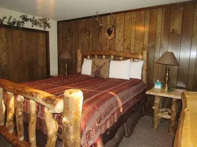 a bedroom with a bed in a room with wooden walls at Gold Rush in Big Bear Lake
