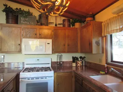 a kitchen with wooden cabinets and a white stove top oven at Gold Rush in Big Bear Lake