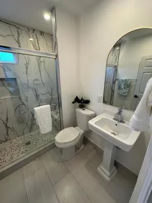 a bathroom with a toilet and a sink and a shower at Coastal Calm Casita in Long Beach