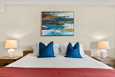 a bedroom with a white bed with blue pillows at Moonstone Quiet Retreat Marina Side Garden view in Los Angeles