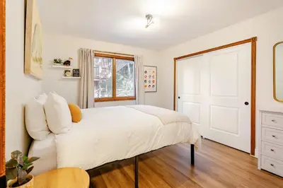 a bedroom with a white bed and a white door at Sleeps 10 Cozy Modern Cabin 4 bedroom 3 bath 2400 sq ft 3 story Updated Quiet cabin in Crestline