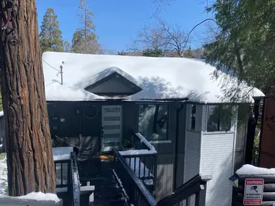 a snow covered house with a snow covered roof at Sleeps 10 Cozy Modern Cabin 4 bedroom 3 bath 2400 sq ft 3 story Updated Quiet cabin in Crestline