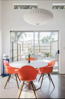 a dining room with a white table and red chairs at Amenity-Rich Abbot Kinney Venice Oasis! in Los Angeles