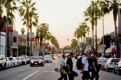 a group of people crossing a city street with a skateboard at Amenity-Rich Abbot Kinney Venice Oasis! in Los Angeles