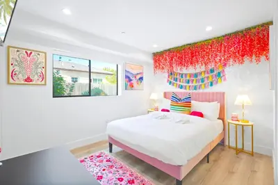 a bedroom with a large white bed with red accents at H- Fab Family 5BD 4,5BA NoHo Escape Near Universal with Games, Deck, Parking in North Hollywood