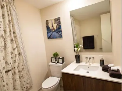 a bathroom with a toilet and a sink with a mirror at Urban Chic residence in Central LA in Los Angeles