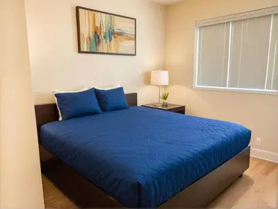 a bedroom with a blue bed and a window at Urban Chic residence in Central LA in Los Angeles