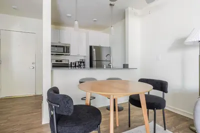 a kitchen with a wooden table and chairs at Blueground Pasadena pool nr Pasadena Park LAX-1391 in Los Angeles