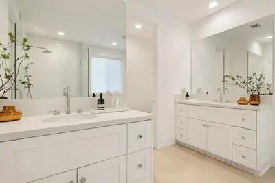 a white bathroom with two sinks and a large mirror at 4mil WestLA Lux Manor Santa Monica and Beverly Hills in Los Angeles