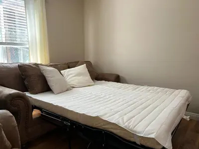 a bed sitting on top of a couch in a room at Cozy Cabin in Crestline
