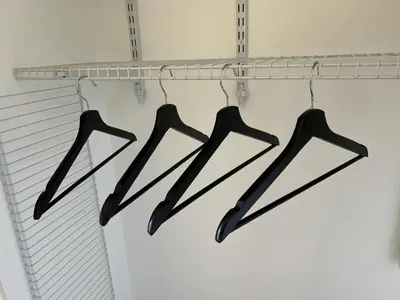 four black tongs hanging from a rack in a closet at Cozy Cabin in Crestline