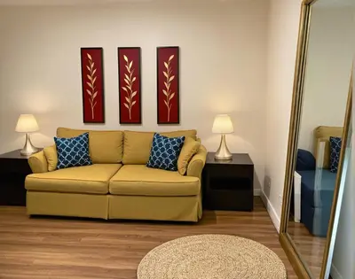 a living room with a couch and a mirror at Venice Beach Getaway Steps from the Ocean Marina and Boardwalk in Los Angeles