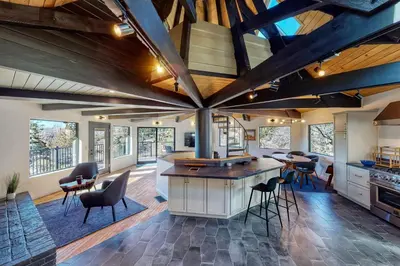 an open kitchen with a large ceiling with exposed beams at Koda House in Lake Arrowhead