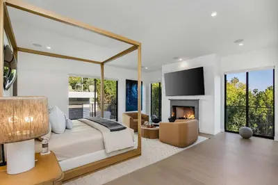 a bedroom with a large bed and a fireplace at Amara by Stay Awhile Villas in Los Angeles