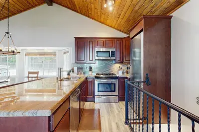 a kitchen with wooden cabinets and stainless steel appliances at Lakeview Lookout in Skyforest