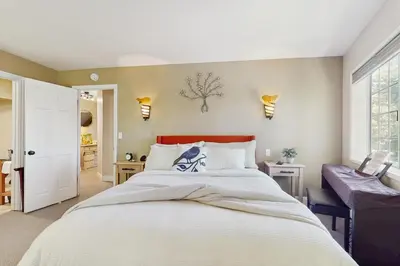 a bedroom with a large white bed and a window at Lakeview Lookout in Skyforest