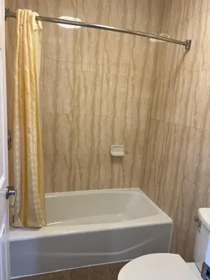 a bathroom with a tub and a toilet and a shower at Carlton Motor Lodge in Los Angeles