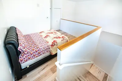 a small bedroom with a bed with a flowered blanket at Modern 2 Bedroom 3 Level Loft by Hollywood Close to Downtown LA Free Gated Parking Full Kitchen in Los Angeles