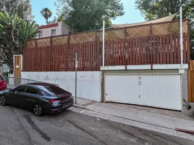 a black car parked in front of a fence at Silver Lake Cozy Getaway in Los Angeles