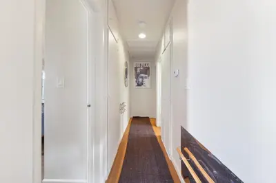 a hallway with white walls and a wooden bench at Silver Lake Cozy Getaway in Los Angeles