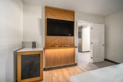 a living room with a flat screen tv on a wall at LYFE INN & SUITES by AGA- North Hollywood Near Universal Studios in North Hollywood