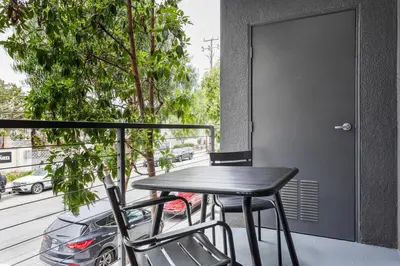 a black table and chairs on a balcony with a car at Blueground Playa Vista pool nr Ballona Creek LAX-1376 in Los Angeles
