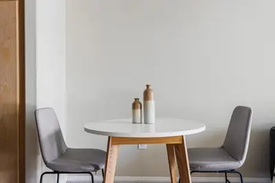 a table with two chairs and a white table with two bottles on it at Blueground Playa Vista pool nr Ballona Creek LAX-1376 in Los Angeles