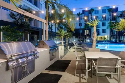 a patio with a grill and a table and a pool at Blueground Playa Vista pool nr Ballona Creek LAX-1376 in Los Angeles