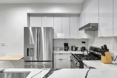 a kitchen with white cabinets and a stainless steel refrigerator at 546 Havard in Los Angeles