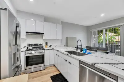 a kitchen with white cabinets and stainless steel appliances at 546 Havard in Los Angeles